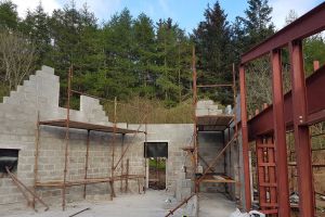 The wall on the left has to be constructed to follow the slope of the structural steel beam on the right. The eastern end of the house contains a mezzanine, above the kitchen. The apex of the roof is just beyond the highest point of the steel; it then slopes down more gently to meet the east wall.