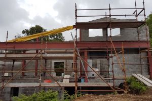 Looking at the house from the front: the mezzanine wall (right) has been built up to roof height and the apex of the roof is now clear to see.