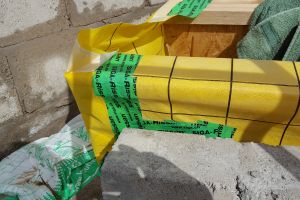 This is one of the tricky corner junctions, where i-beams meet blocks,  that Mike has to keep an eye on to ensure airtightness isn't compromised. The yellow membrane is wrapped around the end of the i-beam and taped down securely.