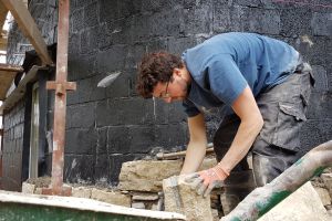Meanwhile, Frankie is selecting and preparing the next stone. The wall behind him is curved, which offers extra challenges.
