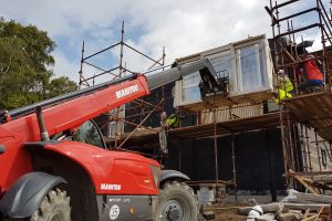 A few tense moments as the telehandler lifts the big south and west-facing windows into the house. They're not being installed just yet, but will be better protected in the house.