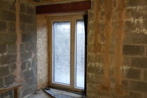 OSB is installed in the reveals first, then airtightness tape is applied where the boards meet the window. Plasterboard is then applied on top. The tape will ensure that if the paint or plaster cracks in these areas, as it can do over time, there won't be a leak in the airtightness barrier.