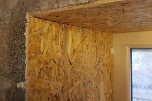 Any gaps or holes, where the OSB meets the blocks or the window, are filled with expanding foam, which is then sliced off neatly before taping.