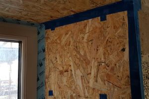 The airtightness tape is applied next. Airtightness tape has a very strong adhesive, and sticks well to wood and metal surfaces, but where it laps over onto concrete or stone, the surface must be pre-painted with a PVA-type adhesive first, to make sure that it sticks well.