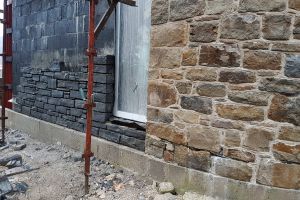 Work has begun on the final section of the east wall; the dark sandstone provides an interesting contrast to the natural sandstone.