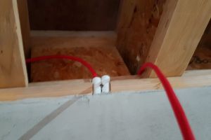 The following day, we begin installing cables in the main living space, threading them through holes drilled in the i-beams and down into the conduits, which have now been plastered in.