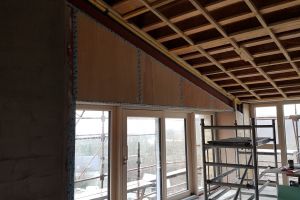 The timber-frame sections of wall built above the south-facing windows have now been boarded in.