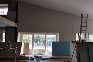 Having finished the kitchen ceiling, the builders move on to applying plasterboard to the south wall and window reveals.