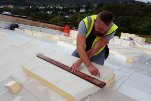 The roofers continue their work during breaks in the rain: 300mm of insulation is installed on top of the membrane.